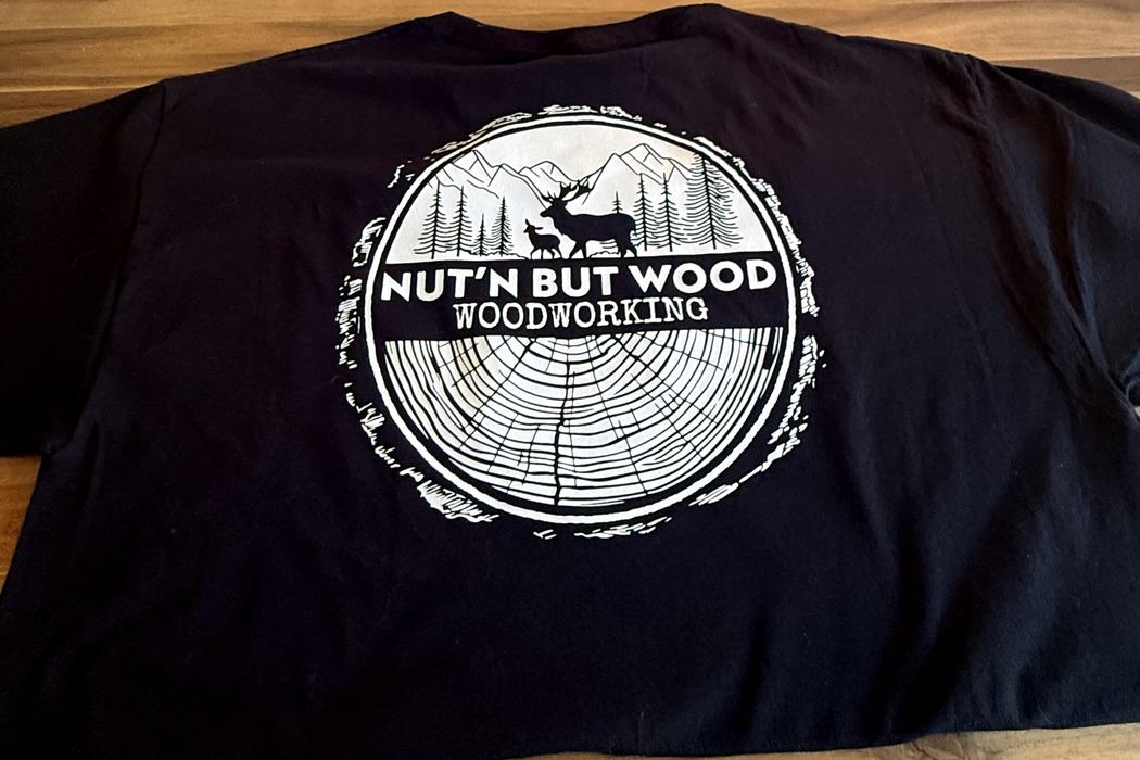 Back print on a Nut’n But Wood tee — log-round badge with elk and mountains.