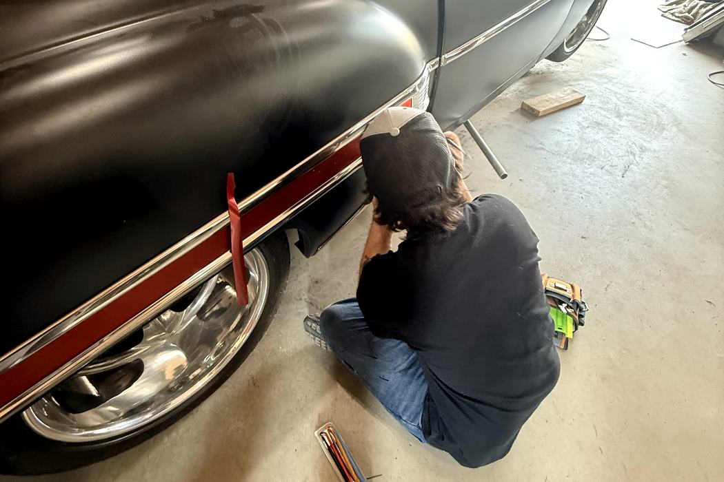 Working along the chrome spear, squeegeeing the vinyl insert into place.
