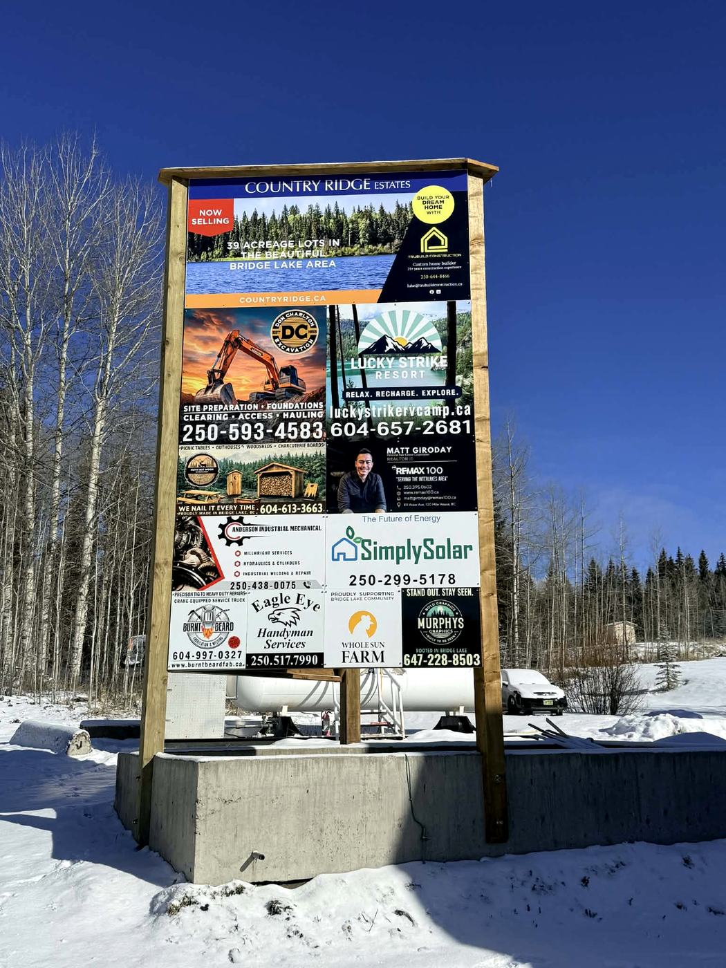 Second Cariboo roadside board with printed panels for local businesses.