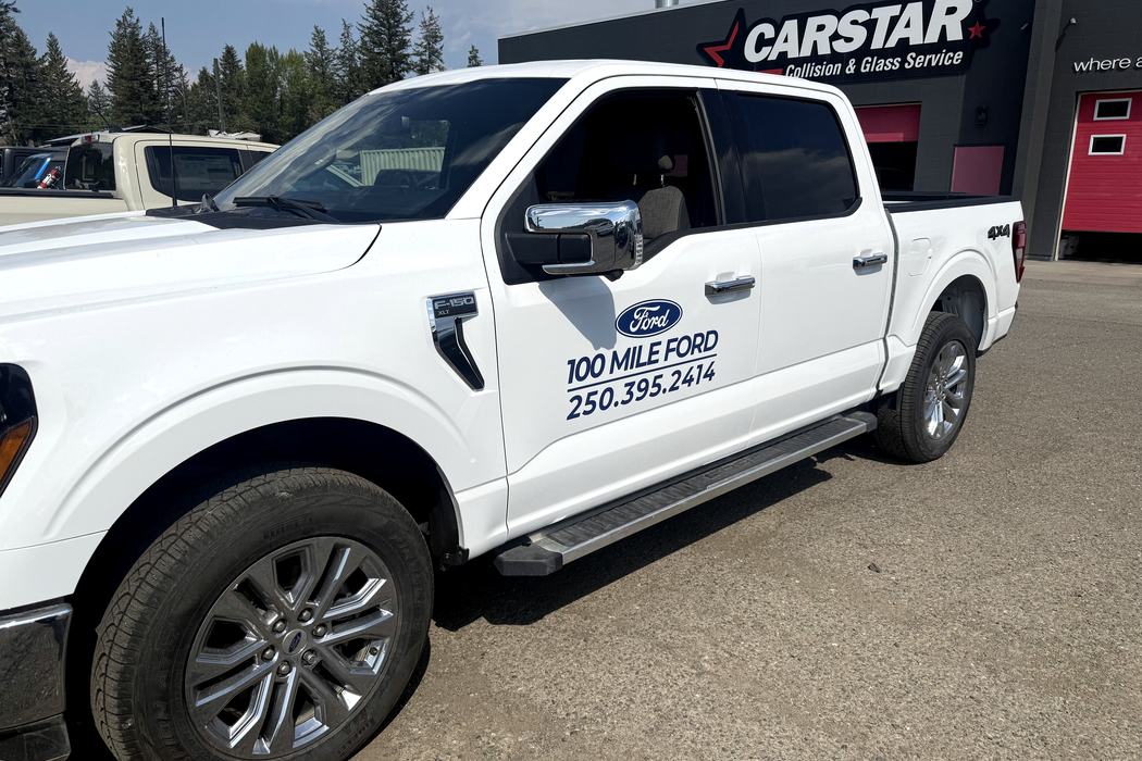 Ford Ranger with 100 Mile Ford door decals on the lot.